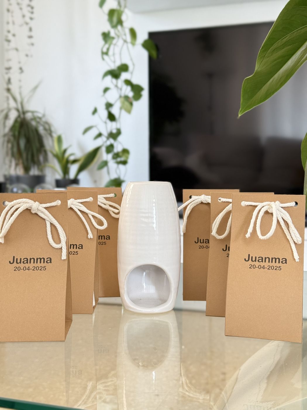 Quemador de cerámica blanco entre bolsas kraft con nombre y fecha